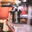 Cruche noire pour mousser le lait de Barista a Co Dial d'une capacité de 60 ml posée sur un café avec un arrière-plan coloré. Cruche noire pour mousser le lait de Barista a Co Dial d'une capacité de 60 ml posée sur un café avec un arrière-plan coloré.