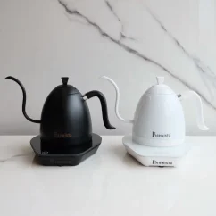 Élégante bouilloire blanche Brewista avec un col de cygne et une poignée confortable à côté du même modèle dans une finition noire mate luxueuse. Élégante bouilloire blanche Brewista avec un col de cygne et une poignée confortable à côté du même modèle dans une finition noire mate luxueuse.