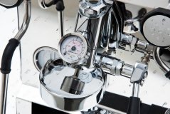 Selwechte Manometer vun der Säit, mat engem méi laangen zylindresche Gehäus an enger duebeler Skala a Bar a Psi.