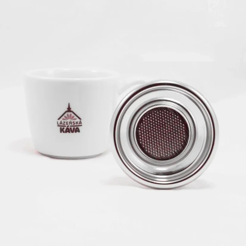 IMS panier argenté sur fond blanc avec une tasse de café, détail du bas du panier.