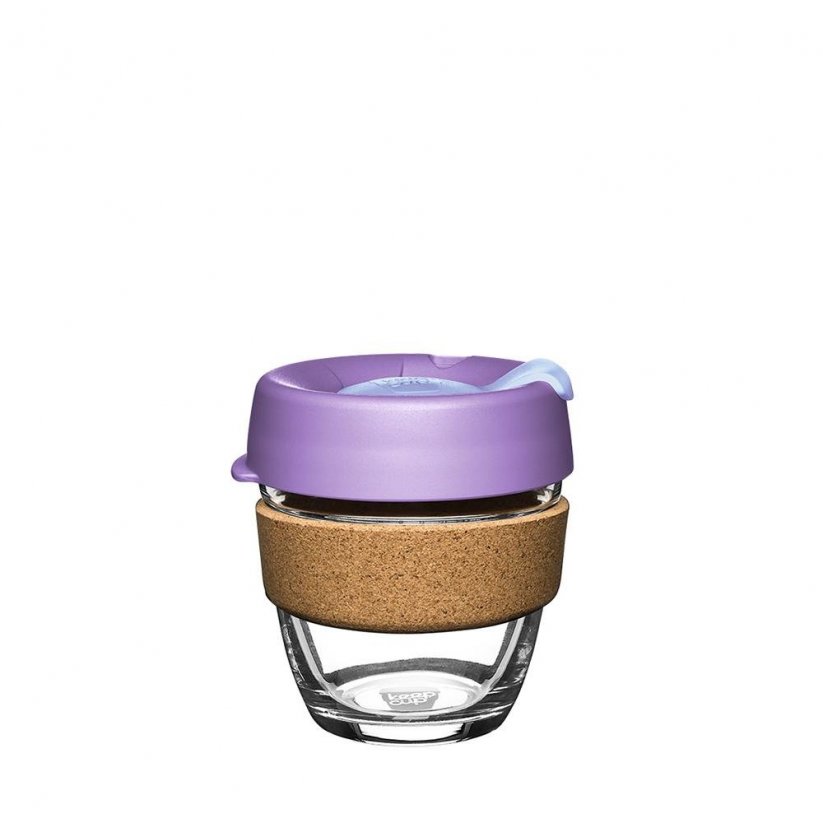 Tazza da caffè in vetro con coperchio viola e supporto in sughero.