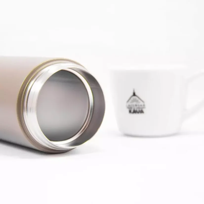 Aperçu de la bouteille Kinto Travel Tumbler Khaki 350ml sur une table blanche avec une tasse.