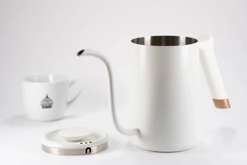 Open 0.7l Timemore Fish Pure Over fast-boiling kettle in white, on a white background with a lid and a porcelain cup with coffee motifs; Gooseneck kettle