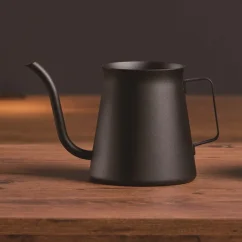 Black Hario Kasuya Mini Drip kettle with a capacity of 300ml on a wooden table against a black background