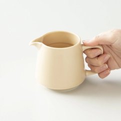 Beigefarbener Kaffeeserver für Filterkaffee in der Hand.