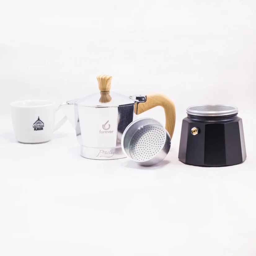 View of an unfolded moka pot with a wooden handle for 3 cups of coffee, accompanied by a cup of coffee.