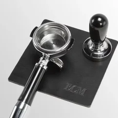 Leather mat with portafilter and coffee tamper.