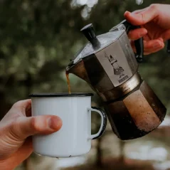 Verser le café préparé dans une cafetière Bialetti Moka Express dans une tasse en métal.