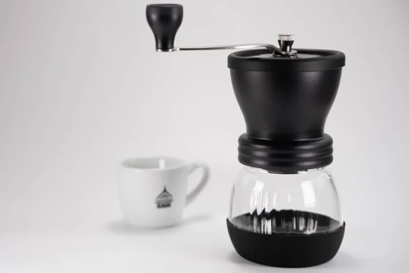 Hario Skerton plus čierny ručný mlynček na kávu s hrnčekom kávy