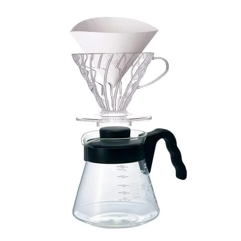 Plastic dripper with a paper filter and glass container with a black handle.