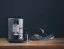 Cafetière argentée Nivona 799 avec préparation de cappuccino, posée sur une table.