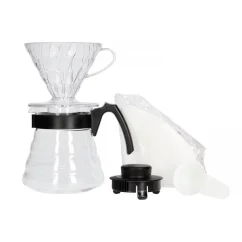 Zestaw Hario V60-02 Pour Over Kit z dzbankiem szklanym, przezroczystym plastikowym dripperem i czarną plastikową pokrywką.
