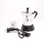 Silver moka pot with accessories and heating element by Bialetti Moka Elettrika Standard, with a cup of coffee in the background.