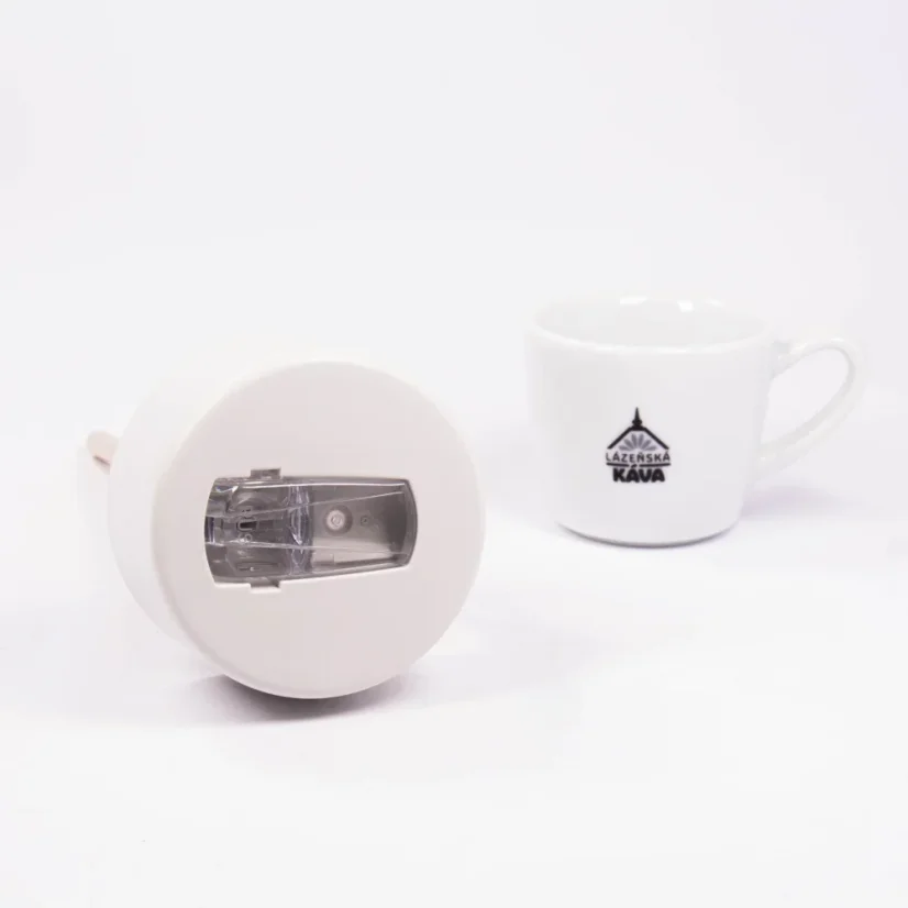 Szczegóły ceramicznego kubka termicznego z kawą w tle