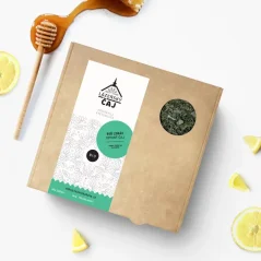 Loose leaf tea "Be Healthy" in a paper box with a logo in the background and a honey dipper.