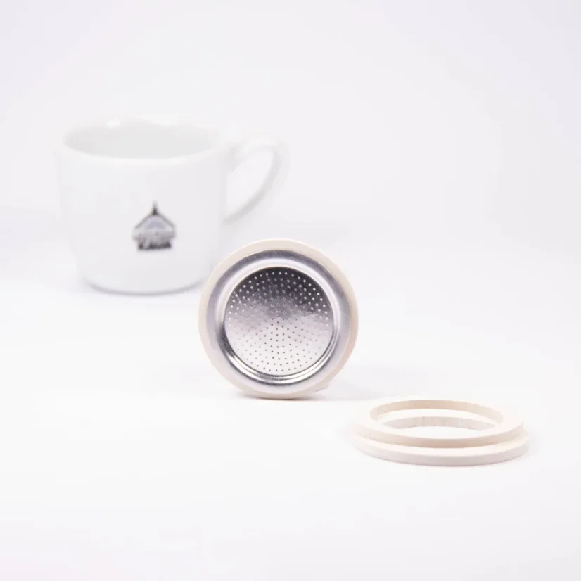 Bialetti tömítések a mokka kávéfőzőhöz, 1 alumínium - 3 tömítés + 1 szűrő a háttérben kávéval.