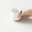 Tazza da caffè con filtro Origami Pinot Flavor bianco in mano.