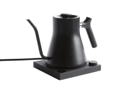 Czarna elektryczna czajnik na czarnym podstawie na białym tle, widok z boku.