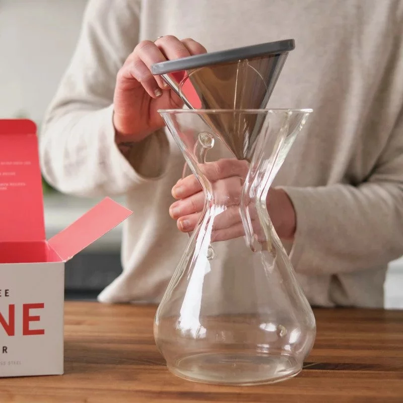 Einsetzen eines Filters in den Behälter für die Zubereitung von Filterkaffee.