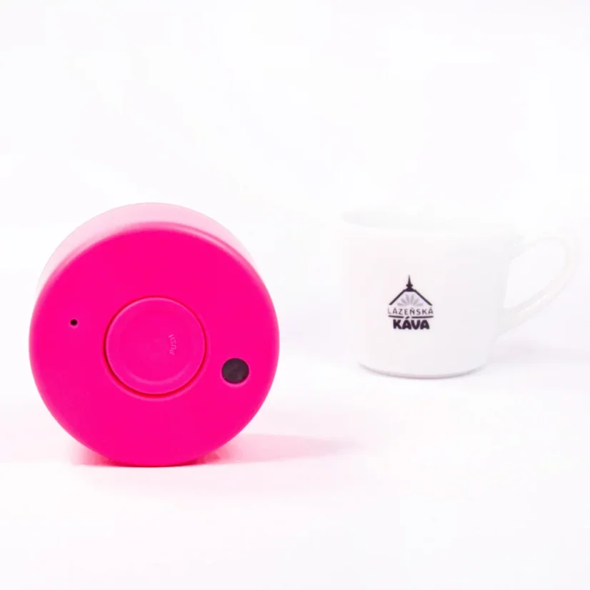 Detail of the thermos cup lid from the top side with coffee in the background.
