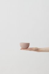 La tazza di caffè Aoomi nel palmo della mano.