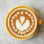 Détail de latte art dans une tasse jaune.