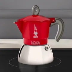 Red moka pot placed on an induction hob.