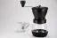 Hario Skerton Plus black manual coffee grinder with a cup of coffee