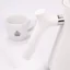Biela elektrická kanvica, detail na rukoväť kanvice, v pozadí šálka kávy.