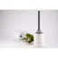 Filtre en plastique blanc avec une structure simple, en arrière-plan une tasse blanche avec une plante.