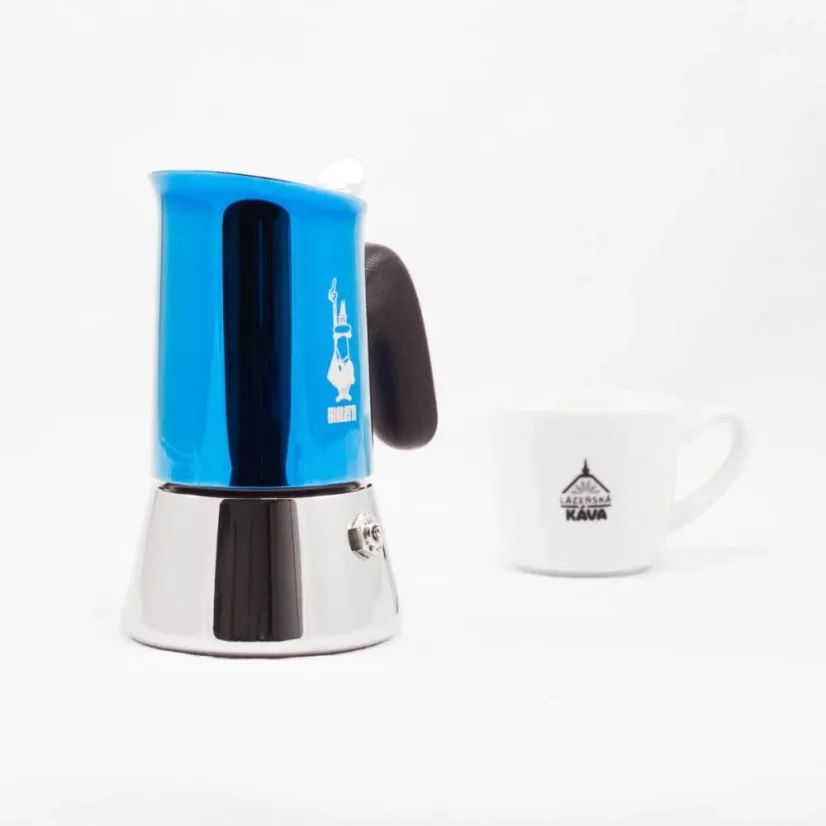 Bialetti New Venus in blue color for 2 cups of coffee with coffee in the background.