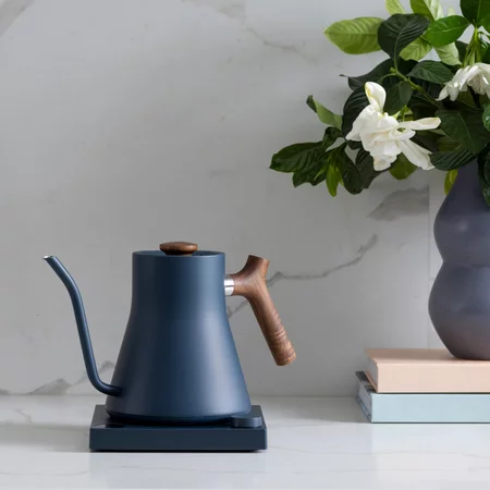 Electric kettle Fellow Stagg EKG for pour-over coffee in blue with a wooden handle and LCD display.