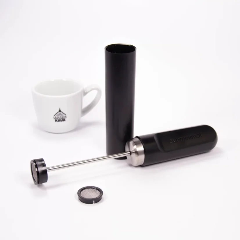 Unboxed Subminimal milk frother next to a cup with a logo.