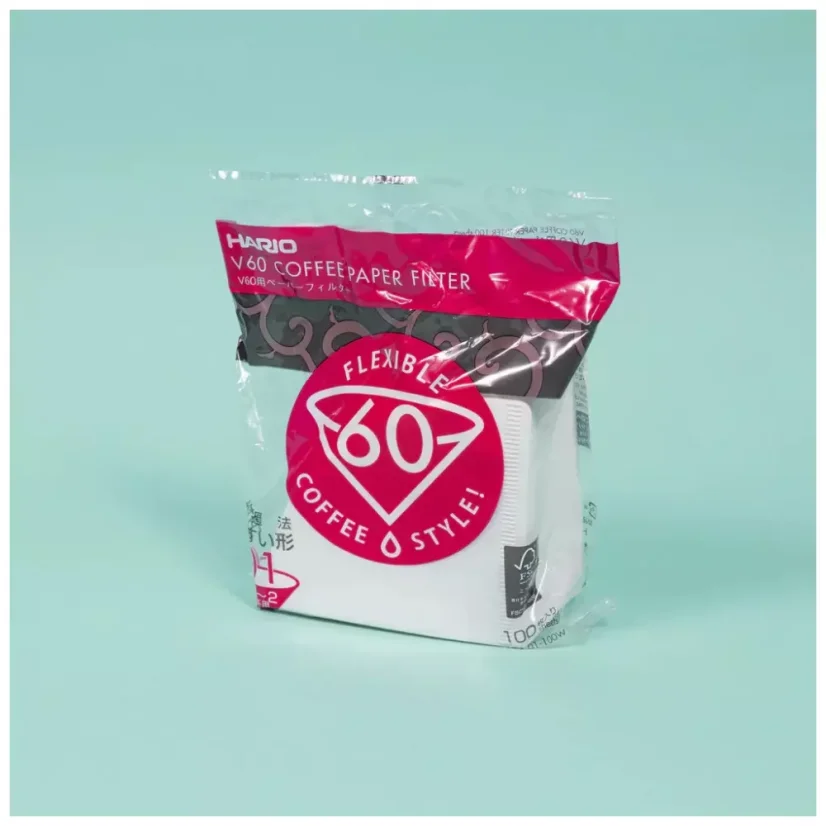 Filtres en papier blancs pour V60 dans un emballage coloré sur un fond coloré.