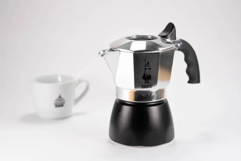 Bialetti Brika moka pot for 2 cups with a coffee cup in the background