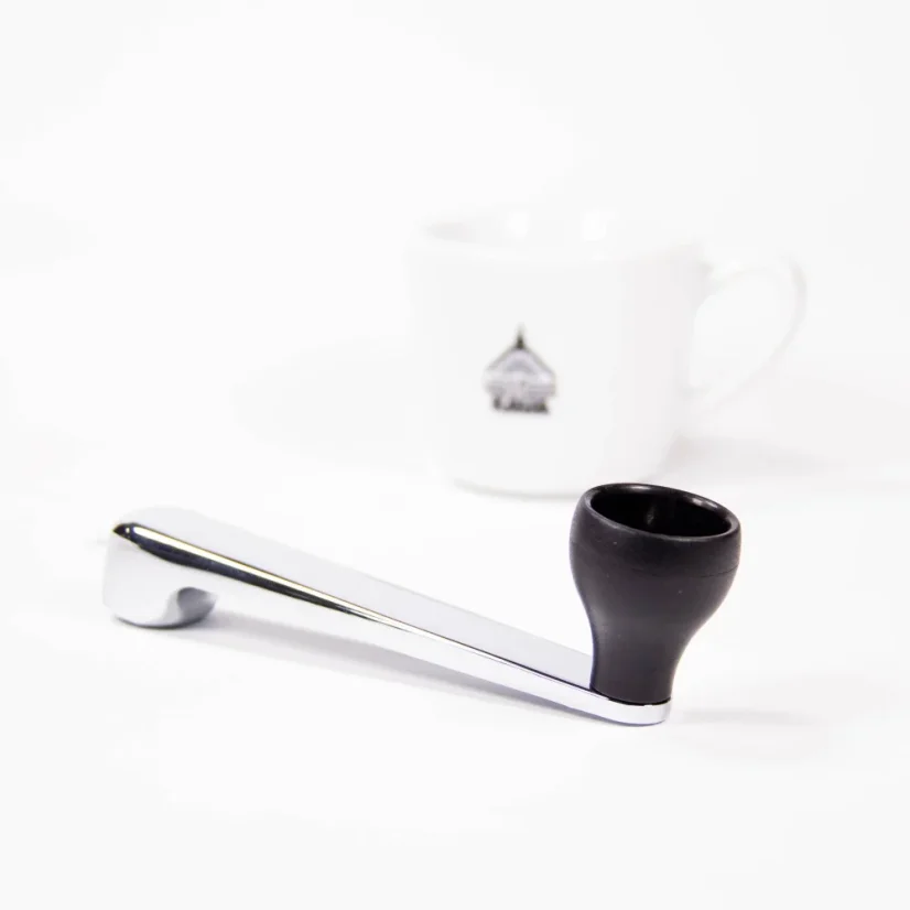 Detail of the handle of the Hario Skerton Pro grinder on a white background with a cup of coffee.