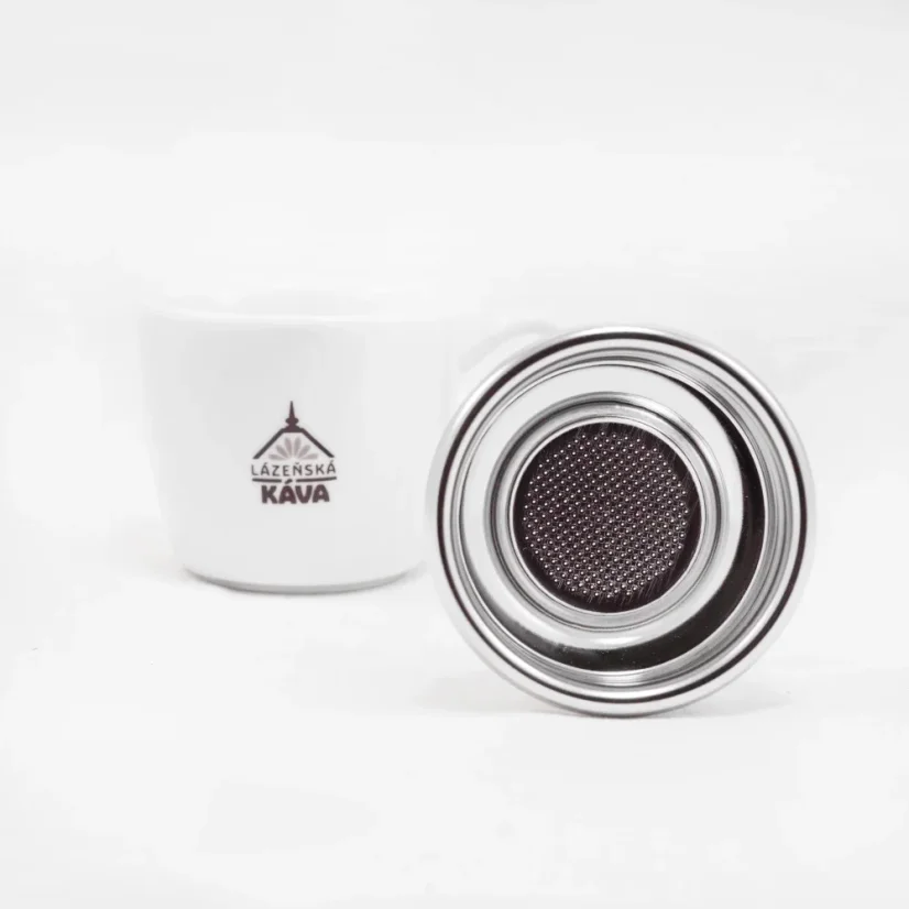 IMS panier argenté sur fond blanc avec une tasse de café, détail sur la partie inférieure du panier.