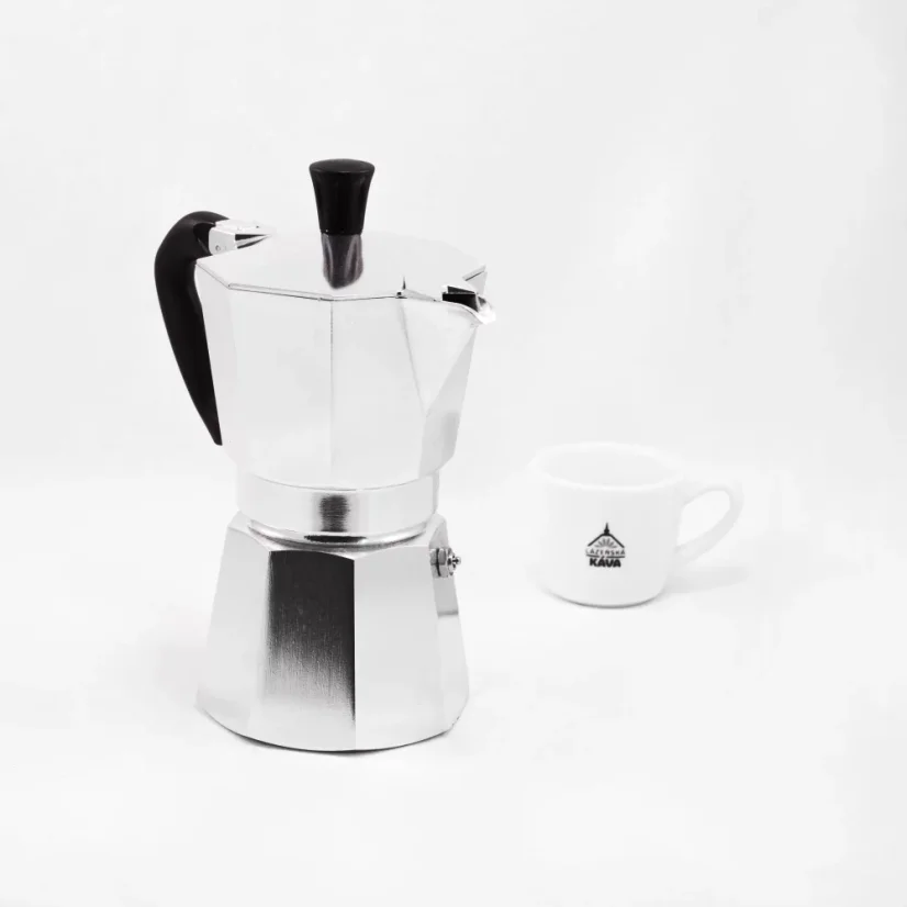 Moka pot of the Italian brand Bialetti Moka Express in the background with a cup featuring a coffee logo.