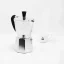 Moka Kanne der italienischen Marke Bialetti Moka Express im Hintergrund mit einer Tasse mit Logo.