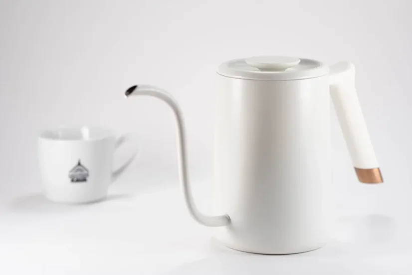 Bouilloire électrique rapide blanche Timemore Fish Pure Over sur un fond blanc avec une tasse décorée.