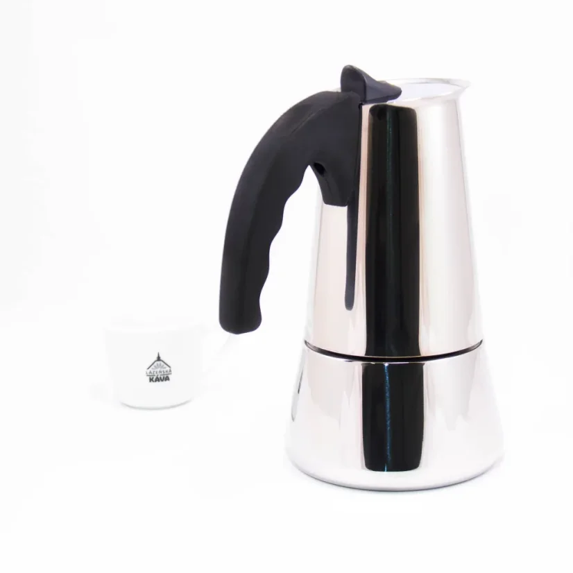 Silver moka pot with a black handle for 10 cups, detail on the handle with a white background and a cup of coffee.