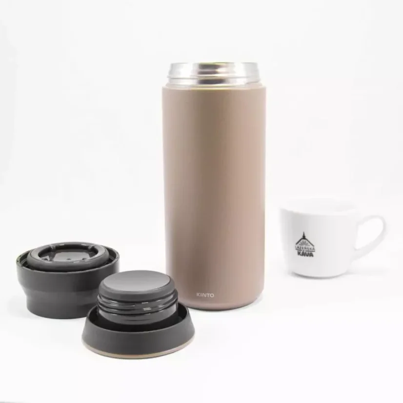 View of an unfolded khaki Kino Travel Tumbler Khaki 350 ml with a cup featuring coffee motifs in the background.