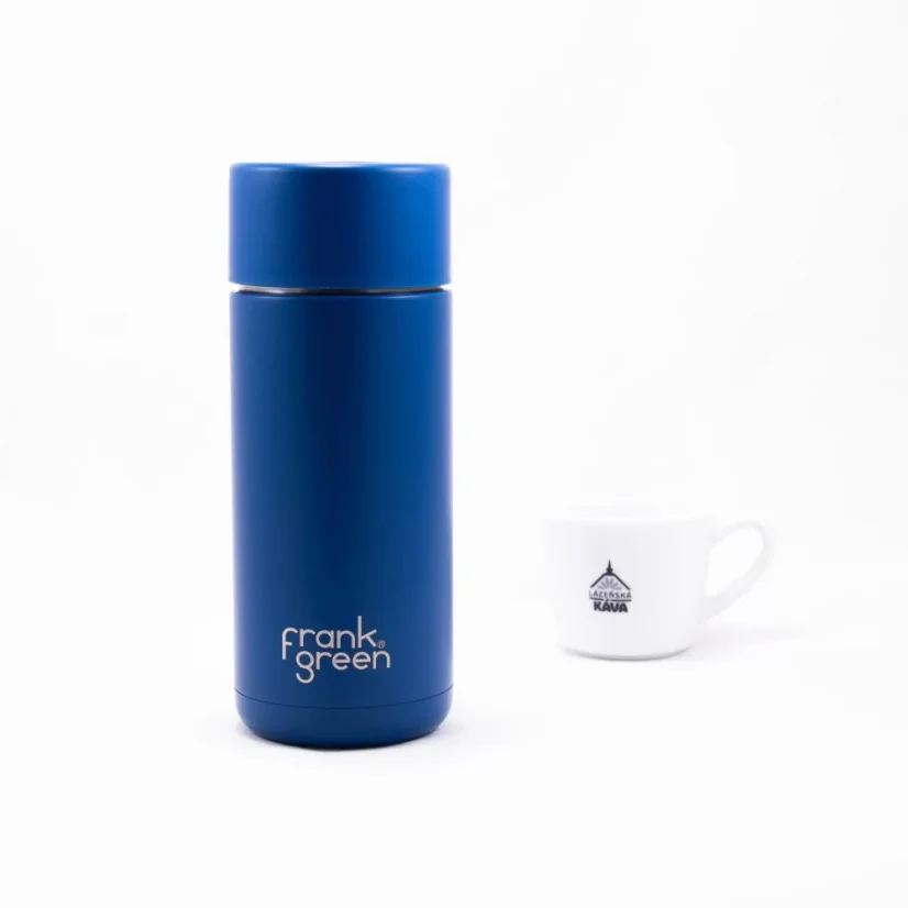 Ceramic thermos from the front with coffee in the background