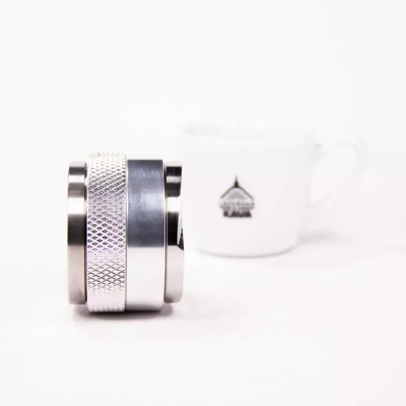 Detail of Rocket Espresso distributor and tamper 58mm in silver with coffee grounds.