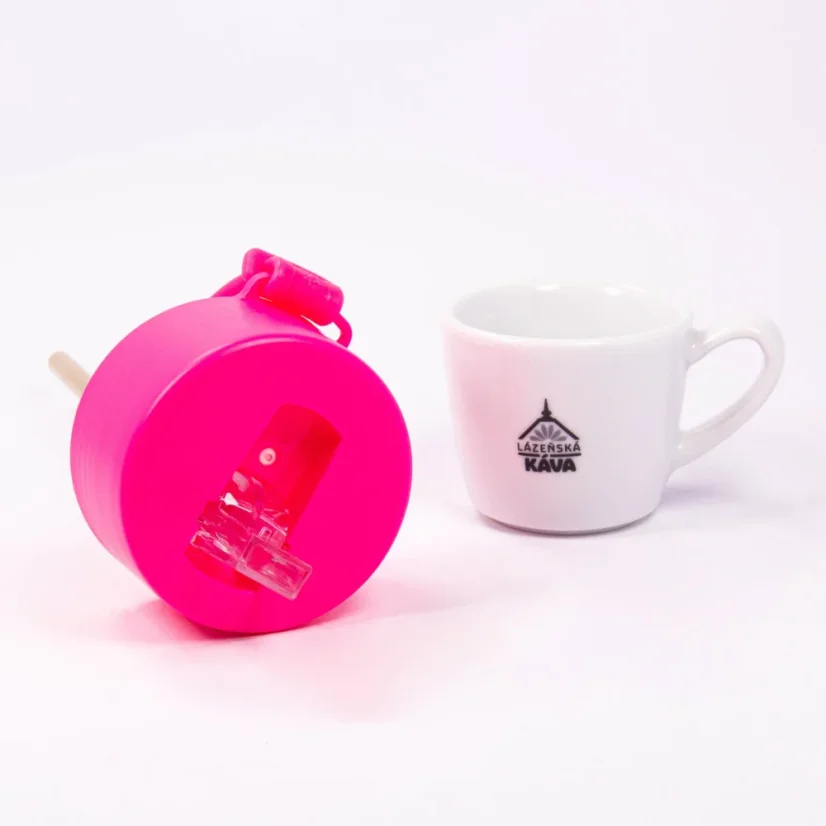 Detail of the drinking spout of the ceramic thermos with coffee in the background