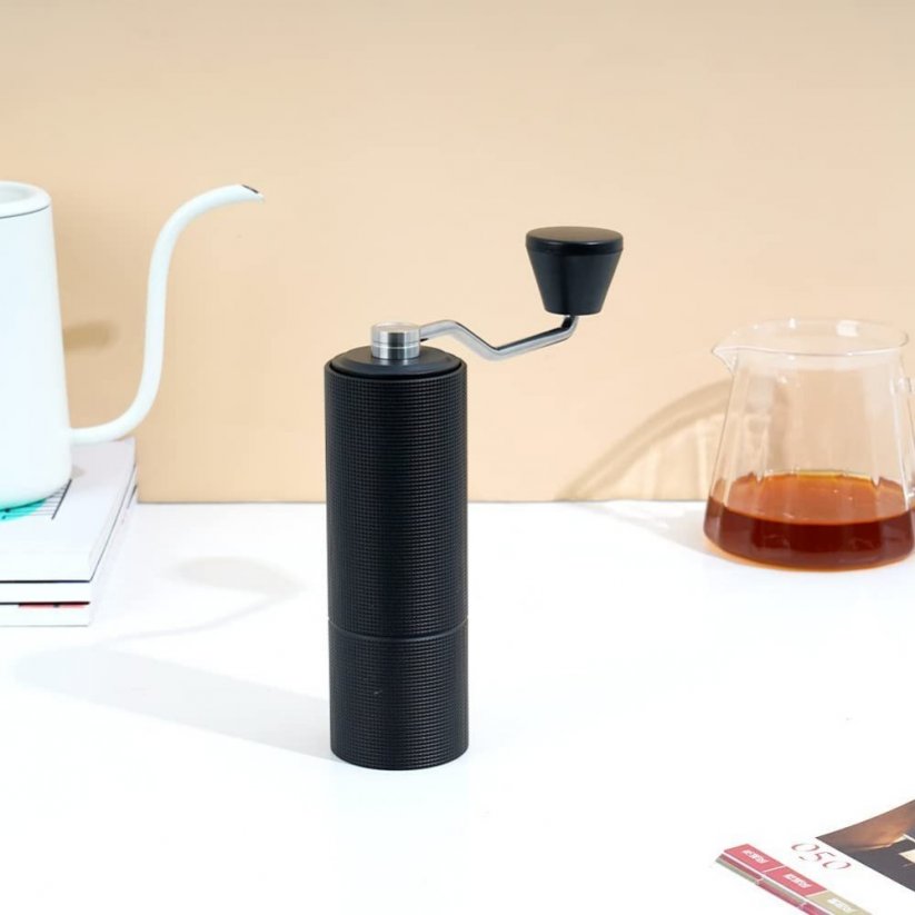 Ručný mlynček na kávu Timemore v čiernej farbe umiestnený na kuchynskej linke.