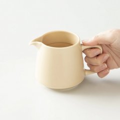 Beige koffieschep voor filterkoffie in de hand.