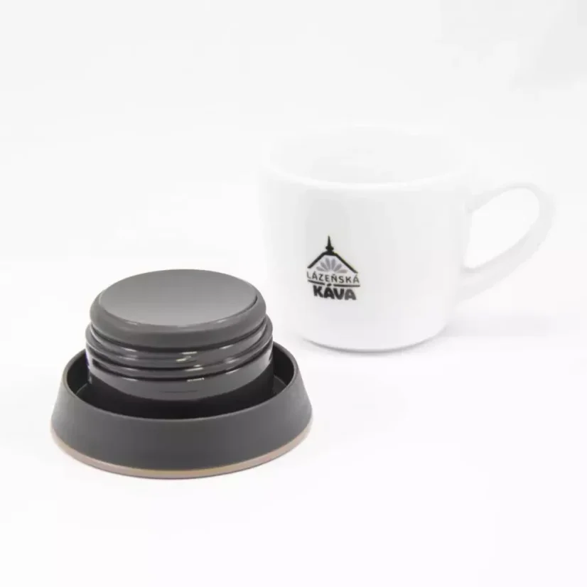 View of the underside of the Kino Travel Tumbler Khaki 500ml lid with a white cup of coffee in the background.