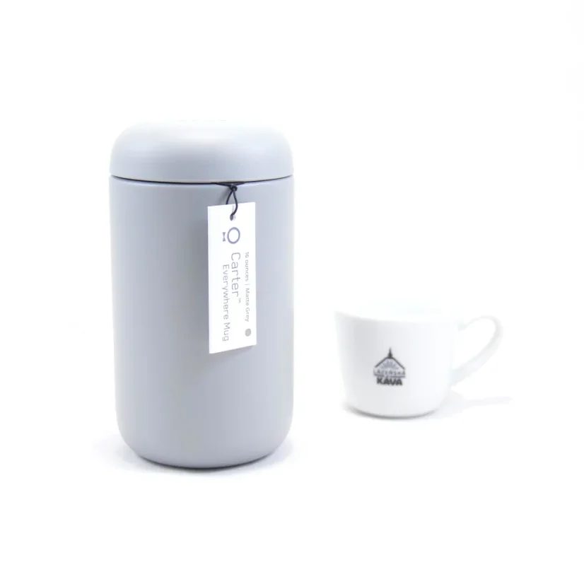 Termo taza desde atrás con café de spa en el fondo.