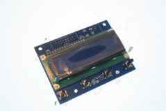 Displayfolie – eng elektronesch Plack mat engem bloe LCD-Panel a zwee Knäpp um Rand Displayfolie – eng elektronesch Plack mat engem bloe LCD-Panel a zwee Knäpp um Rand